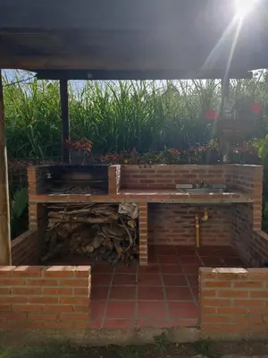 a fire pit under a pergola in a garden at Hotel Casa Linda Guatape in Guatapé