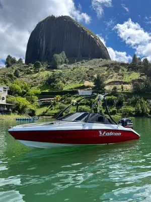 a red and white boat on a body of water at Hotel Casa Linda Guatape in Guatapé