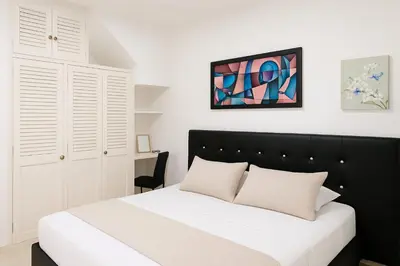 a bedroom with a black and white bed and white cabinets at Apto 201 Sweet Home Medellín in Medellín