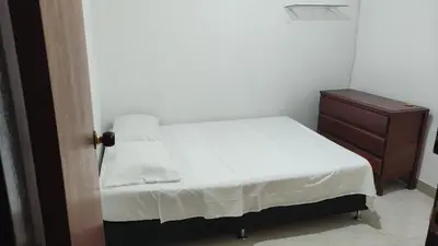 a small bedroom with a white bed and a dresser at Habitación central con cama doble #2 in Medellín