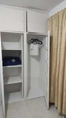 a white closet with shelves and a shower curtain at Habitación central con cama doble #2 in Medellín