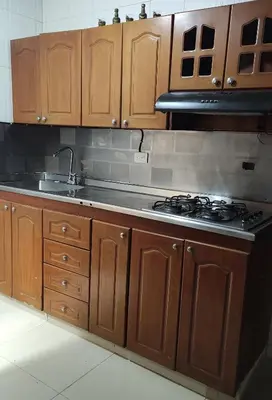a kitchen with wooden cabinets and a stove top oven at Habitación central con cama doble #2 in Medellín
