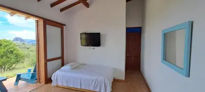 a room with a bed and a tv on a wall at Finca Buena Vista in Guatapé