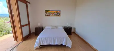 a white bedroom with a bed and a large window at Finca Buena Vista in Guatapé
