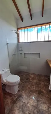 a bathroom with a toilet and a glass shower at Finca Buena Vista in Guatapé