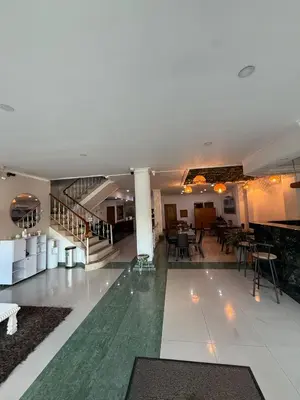 a lobby with a pool and tables and chairs at Hotel Prince Plaza - Laureles Estadio in Medellín