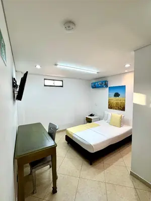 a bedroom with a bed and a desk in it at Hotel Prince Plaza - Laureles Estadio in Medellín