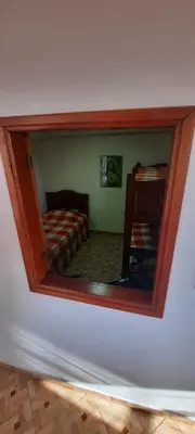 a mirror on a wall with a bed in a room at Casa Hotel los Patios in Jericó