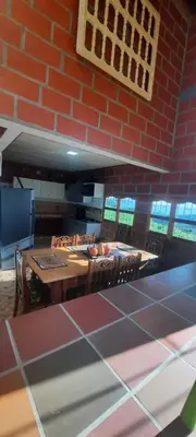 a kitchen with a table and chairs and a brick wall at Casa Hotel los Patios in Jericó