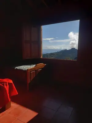 a room with a bed and a window with a view at Casa Hotel los Patios in Jericó