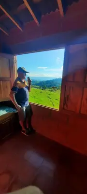 a man standing in front of a large window at Casa Hotel los Patios in Jericó