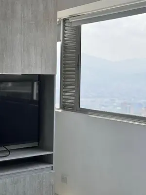 a living room with a tv and a window at 2511 Suite Moderna y de lujo con la mejor vista a la ciudad - Poblado Medellín in Medellín