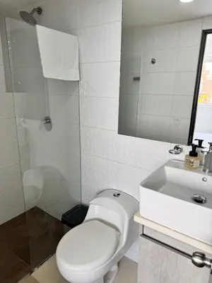 a white bathroom with a toilet and a sink at 2511 Suite Moderna y de lujo con la mejor vista a la ciudad - Poblado Medellín in Medellín
