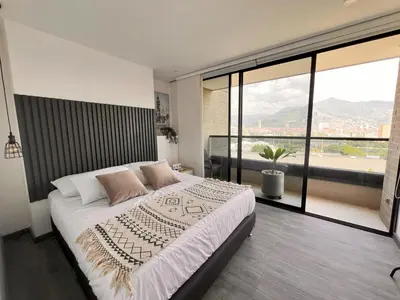 a bedroom with a large bed and a large window at Class 48, Sabaneta in Sabaneta