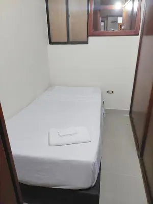 a small room with two beds and a mirror at Cápsula Urbana Central #4 in Medellín
