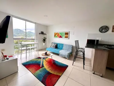 a living room with a blue couch and a table at Acogedor apto 2 habitaciones in Manizales