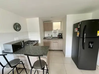a kitchen with a black refrigerator and a counter at Acogedor apto 2 habitaciones in Manizales