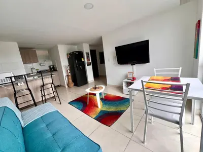 a living room with a couch and a table and a tv at Acogedor apto 2 habitaciones in Manizales