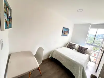 a bedroom with a bed and a desk and a window at Acogedor apto 2 habitaciones in Manizales