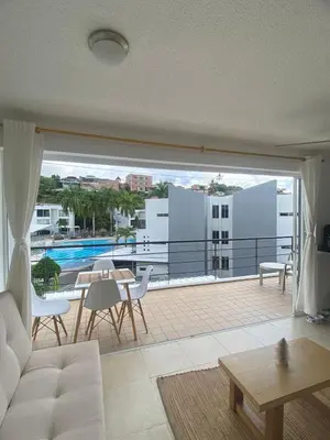a living room with a white couch and a balcony at Apartasol Santa Fe de Antioquia - Ciudadela Santa Fe in Santa Fe de Antioquia