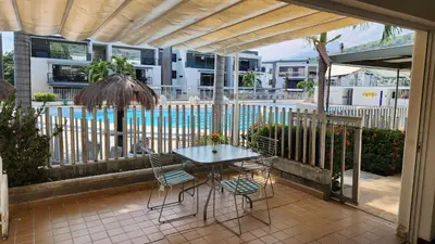 a patio with a table and chairs and a pool at Apartasol Santa Fe de Antioquia - Ciudadela Santa Fe in Santa Fe de Antioquia