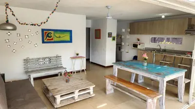 a living room with a table and a kitchen at Apartasol Santa Fe de Antioquia - Ciudadela Santa Fe in Santa Fe de Antioquia
