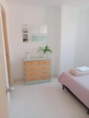 a bedroom with a bed and a dresser with a plant at Hermoso e iluminado apartamento. in Itagüí