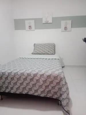 a bed in a white room with a bedskirtspectspectspects at Hermoso e iluminado apartamento. in Itagüí