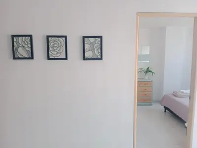 a mirror in a bedroom with four pictures on the wall at Hermoso e iluminado apartamento. in Itagüí