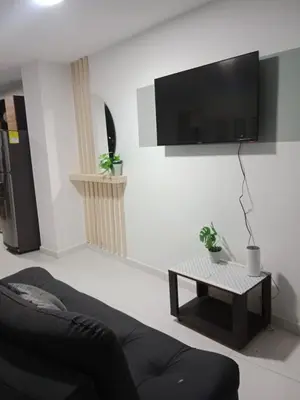 a living room with a couch and a tv on a wall at Hermoso e iluminado apartamento. in Itagüí
