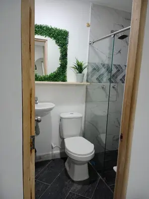a bathroom with a toilet and a sink and a mirror at Hermoso e iluminado apartamento. in Itagüí