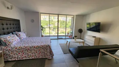 a bedroom with a bed and a living room with a tv at Apartamentos Borbon Suites in Medellín
