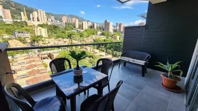 a balcony with a table and chairs and a view at Apartamentos Borbon Suites in Medellín