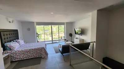 a bedroom with a bed and a desk and a window at Apartamentos Borbon Suites in Medellín