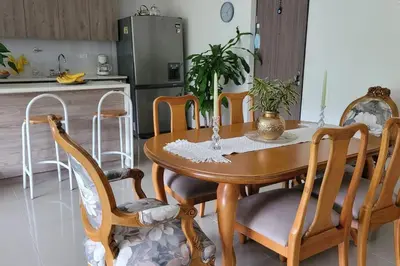 a dining room table with chairs and a kitchen at Estándar Suite en Sabaneta in Sabaneta