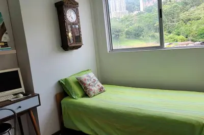 a bedroom with a bed and a clock on the wall at Estándar Suite en Sabaneta in Sabaneta