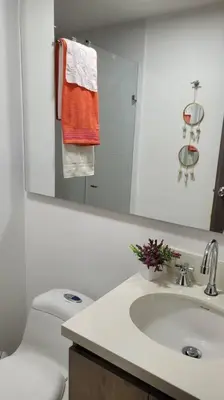 a bathroom with a toilet and a sink and a mirror at Estándar Suite en Sabaneta in Sabaneta