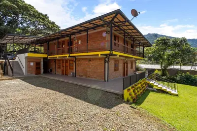 a house with a large deck on the side of it at HOTEL EMBRUJO CAMPESTRE in Jardin