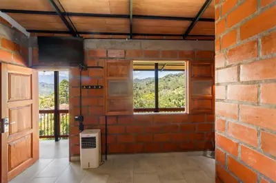 a room with a brick wall and a window at HOTEL EMBRUJO CAMPESTRE in Jardin