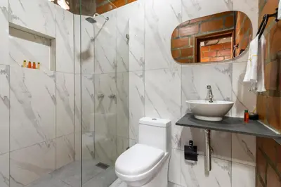 a bathroom with a white toilet and a sink at HOTEL EMBRUJO CAMPESTRE in Jardin