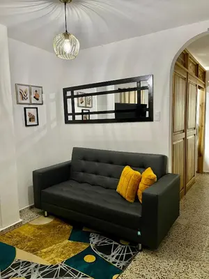 a black couch in a living room with yellow pillows at Hermoso apartamento en zona central de Medellín in Medellín