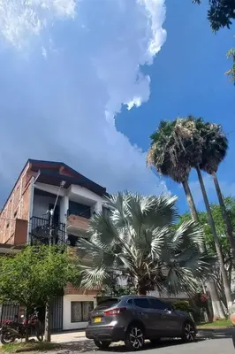 a car parked in front of a building with palm trees at Hermoso apartamento en zona central de Medellín in Medellín