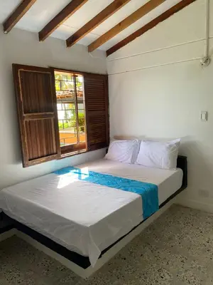 two beds in a room with a window at Mirador del Magdalena in Doradal