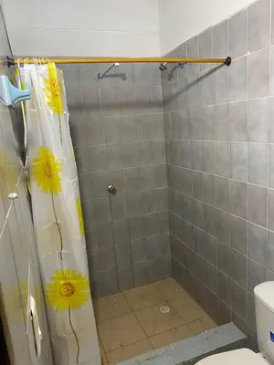 a bathroom with a shower with yellow flowers on the shower curtain at Mirador del Magdalena in Doradal