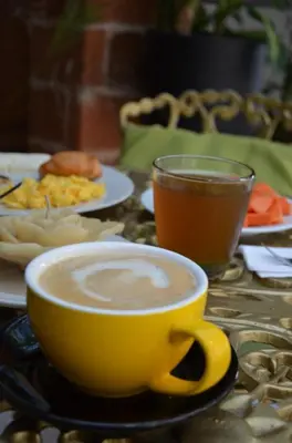 a cup of coffee on a table with plates of food at Selva María Hotel Boutique in Santa Fe de Antioquia