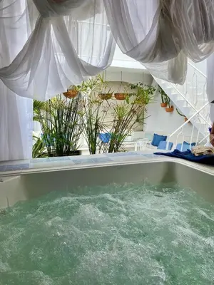 a bath tub filled with water in a room with a window at Selva María Hotel Boutique in Santa Fe de Antioquia