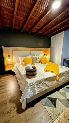 a bedroom with a large bed with yellow pillows at Poblado Muuk Hotel Boutique Campestre in Medellín