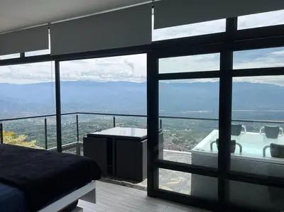 a bedroom with a view of a tub and a bed at Cabaña en Sopetran con jacuzzi in Sopetran