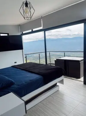 a bedroom with a blue bed on a balcony at Cabaña en Sopetran con jacuzzi in Sopetran