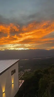 a building with a sunset in the background at Cabaña en Sopetran con jacuzzi in Sopetran